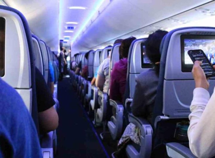 Alcune persone mentre utilizzano il cellulare durante un volo (Depositphotos)